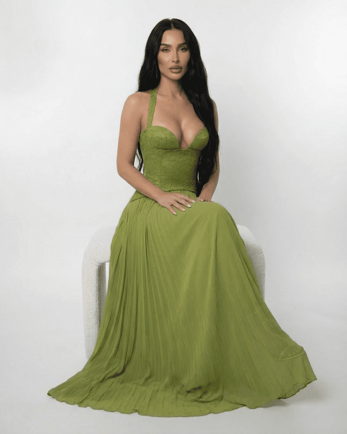 Model showcasing the Verdant Maxi Dress by Lauven, featuring a lace bodice and pleated olive green skirt.