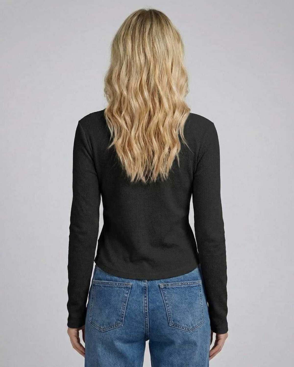 Back view of a woman wearing the Vesper Long Sleeve top in black, showcasing the slim fit and long sleeves.