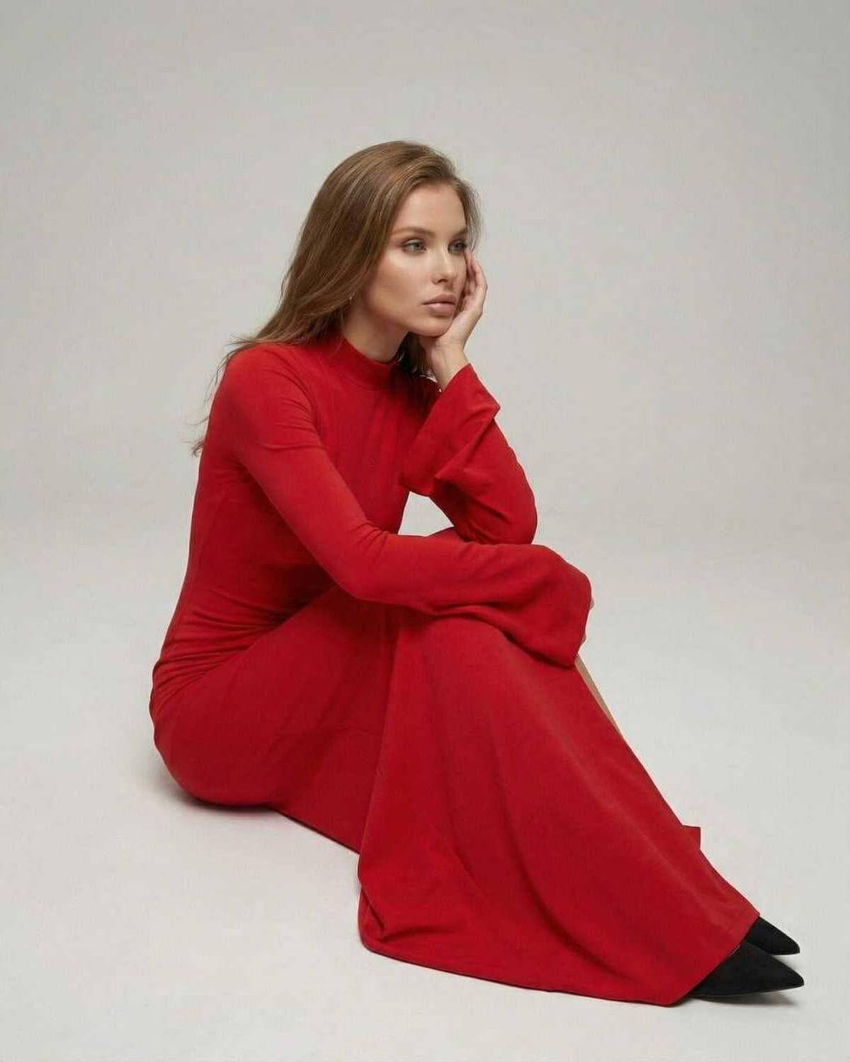 Model wearing the Virella Maxi Dress by Lauven in red with flare sleeves, showcasing a slim fit pencil silhouette.