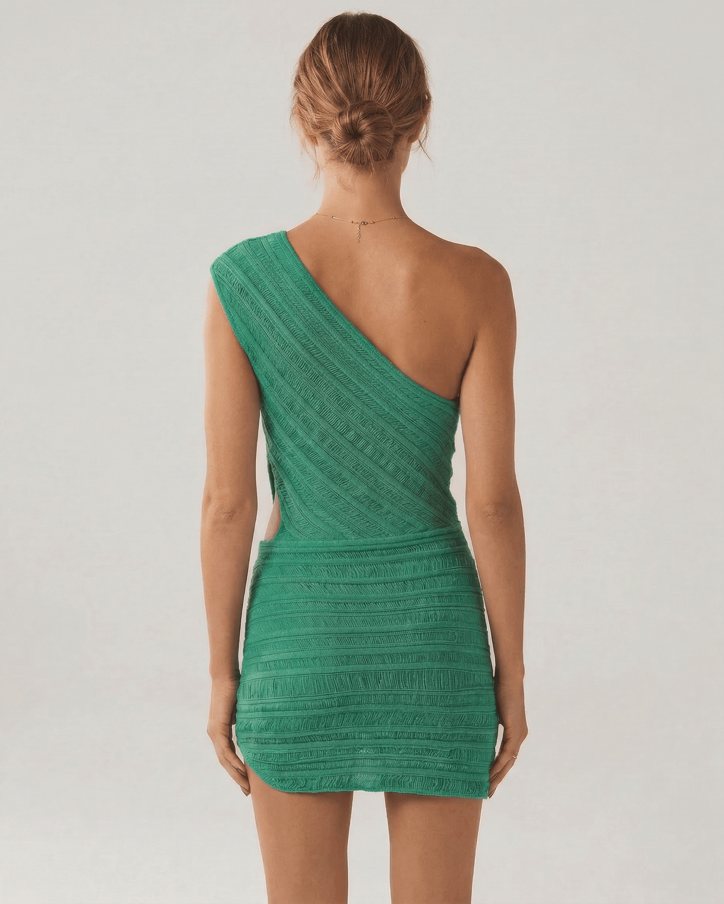 Back view of the Viridian Mini Dress by Lauven in vibrant green, showcasing its unique asymmetrical design.
