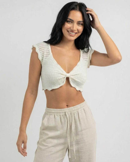 Smiling model wearing Calista Top by Lauven, a women's cotton knit top with lettuce trim and V-neck design.