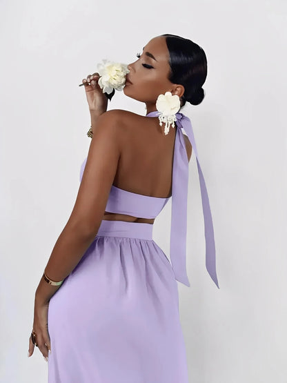 Elegant woman in lavender halter top with ribbon detail, showcasing a chic summer style with a flower accessory.