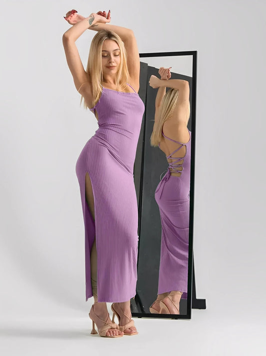 Model wearing a lilac lace midi dress with strappy ribbed fit and lace-up back in front of a mirror.