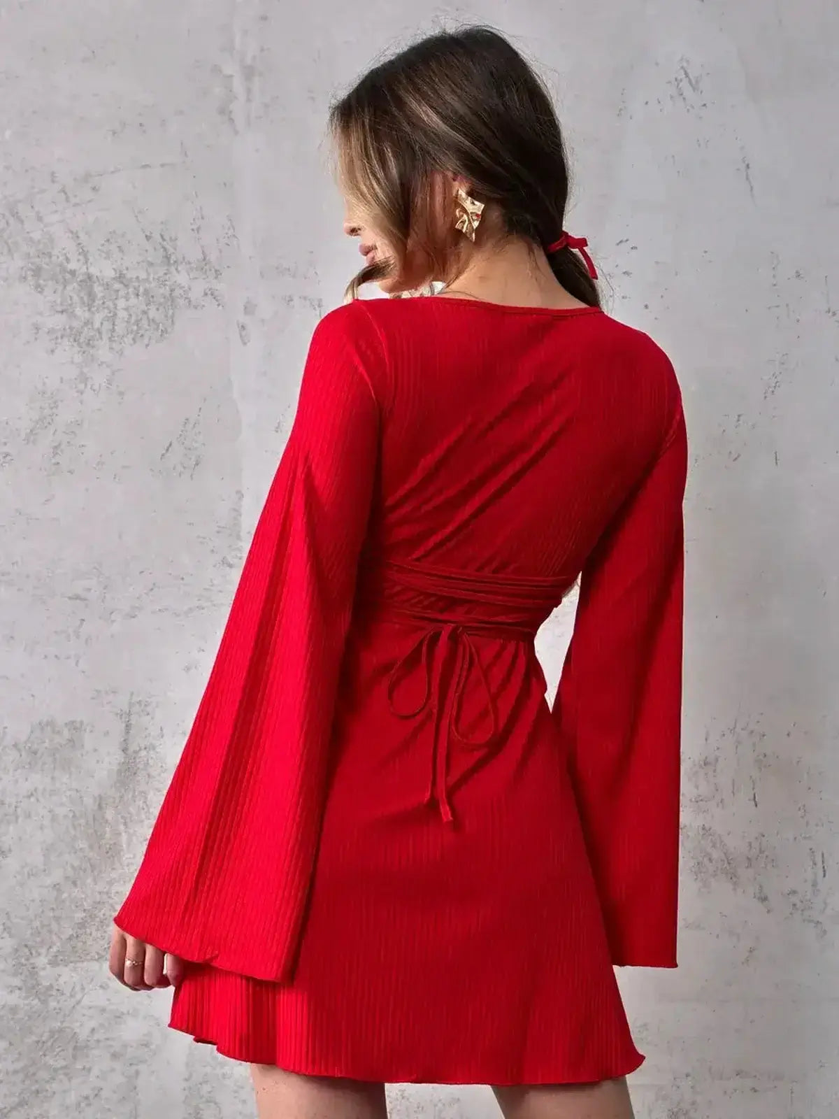 Back view of a red Luna Flare Mini Dress with bell sleeves and waist tie, ideal for summer parties and events.