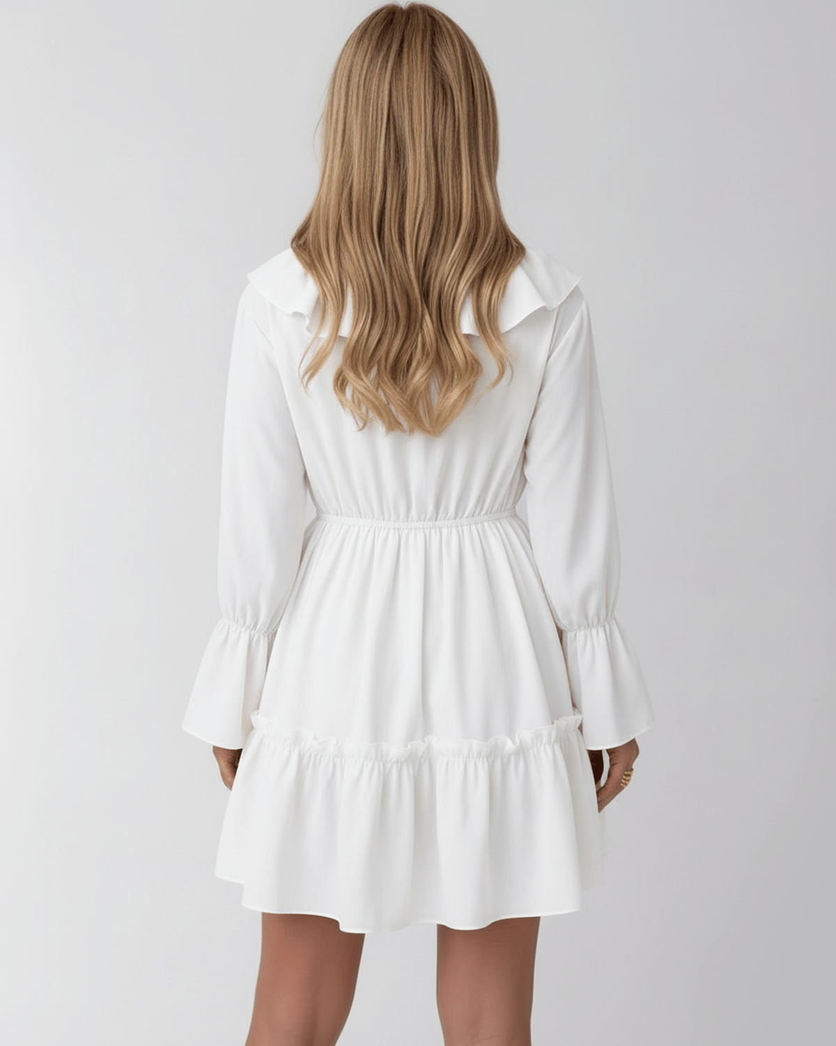 Lauven Luna Mini Dress featuring a ruffled V-neck, elastic waist, and long bell sleeves in classic white.