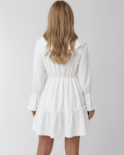 Lauven Luna Mini Dress featuring a ruffled V-neck, elastic waist, and long bell sleeves in classic white.