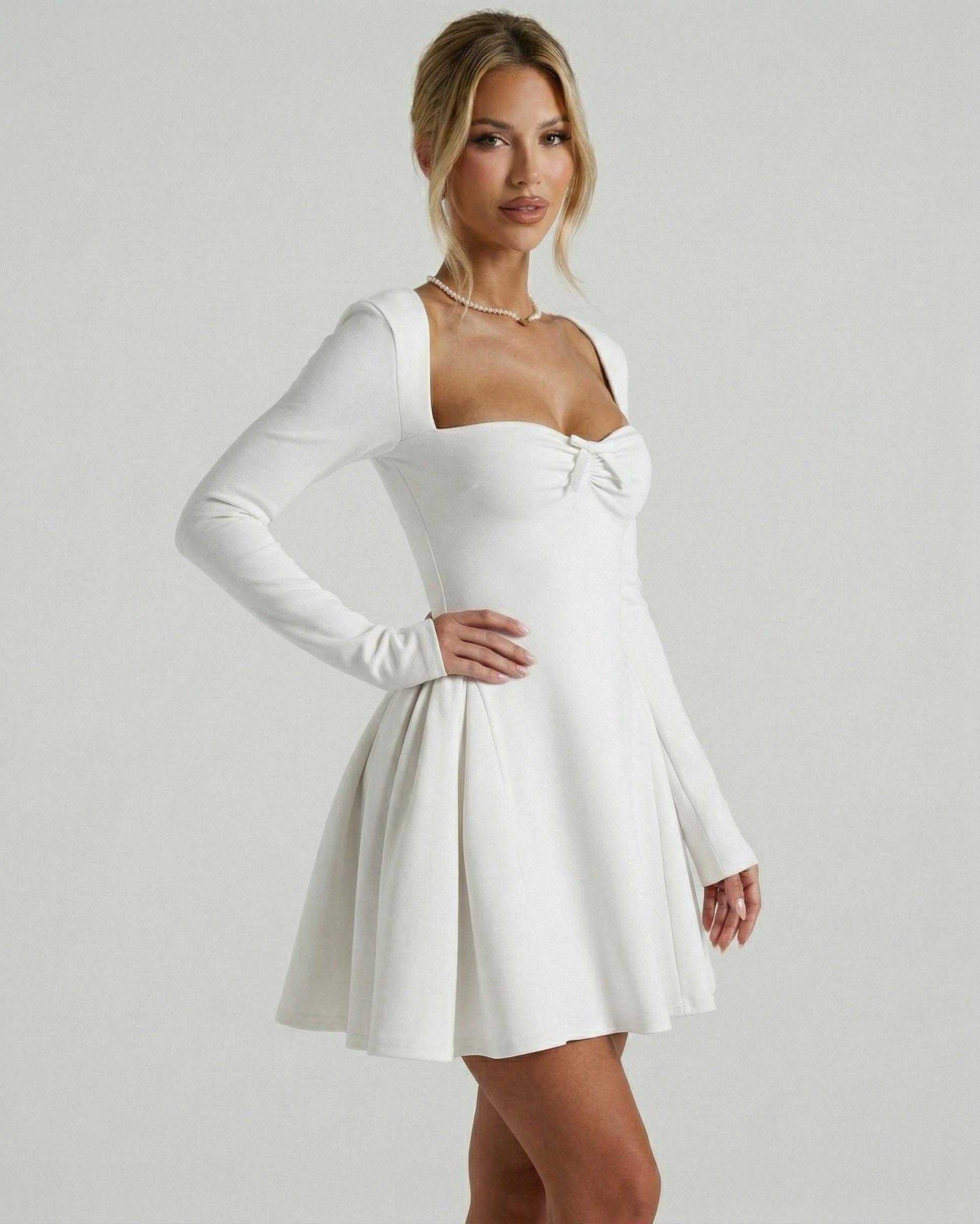 Lauven Luna Mini Dress showcasing a classic white long sleeve fit-and-flare design with a square neckline and ruched bow detail.