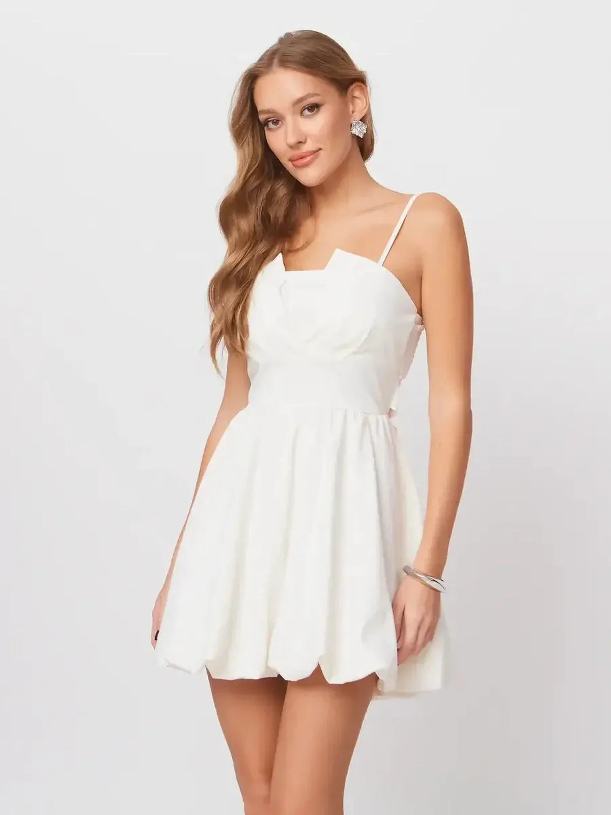 Model wearing a white Luna Mini Dress with adjustable straps and an elegant bow, perfect for summer soirées and weddings.