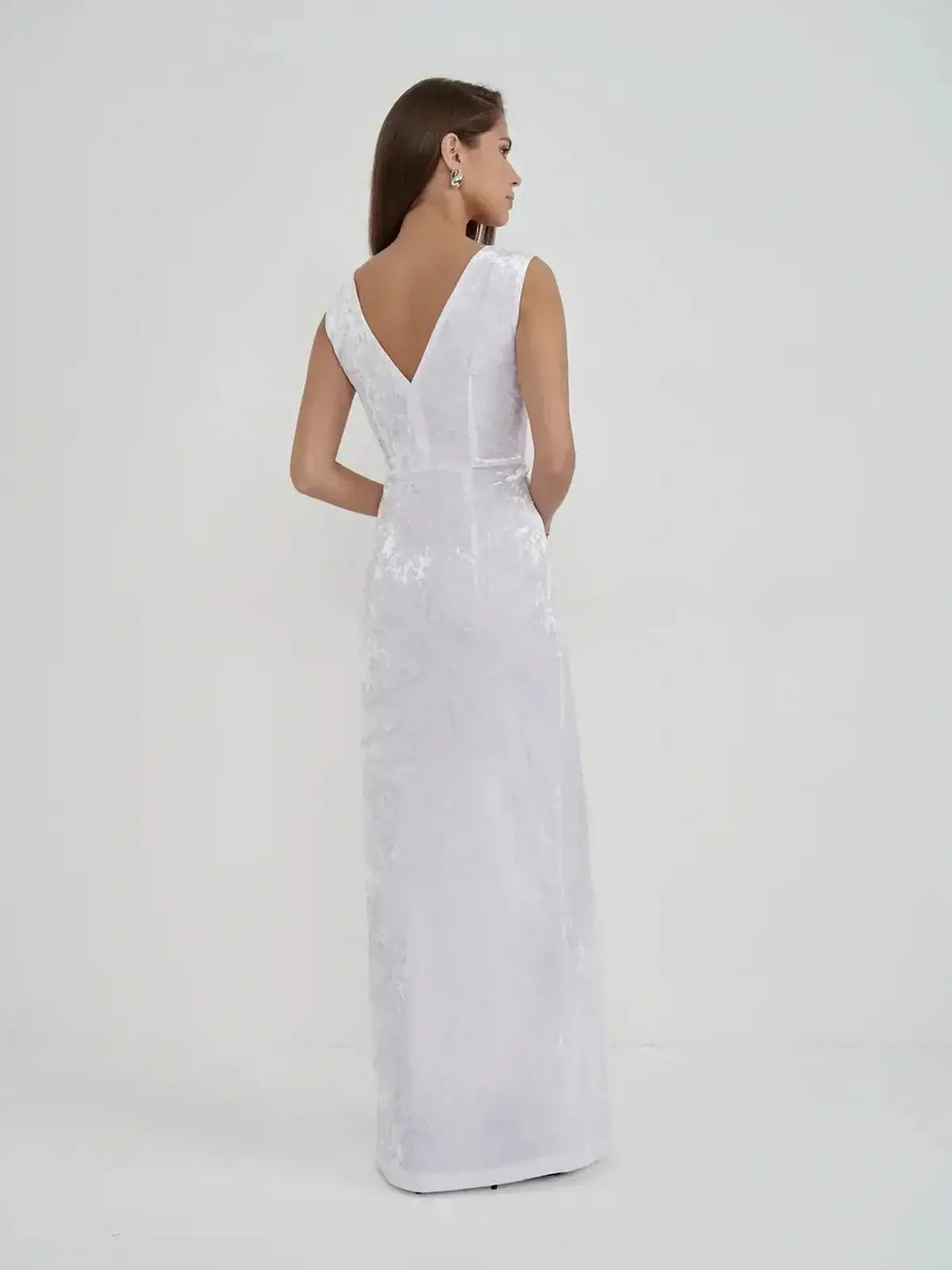 Elegant back view of the Lustre Twist Maxi Dress in white crushed velvet, showcasing its sculptural silhouette and modern design.