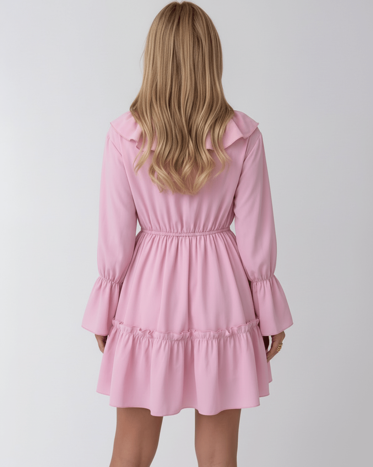 Back view of Lauven Marina Mini Dress in pink with ruffles and elastic waist, featuring long flared sleeves.