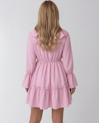 Back view of Lauven Marina Mini Dress in pink with ruffles and elastic waist, featuring long flared sleeves.