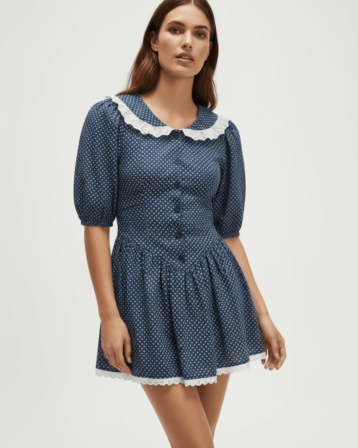 Marinette Mini Dress by Lauven features a light navy polka dot design with Peter Pan collar and puff sleeves.