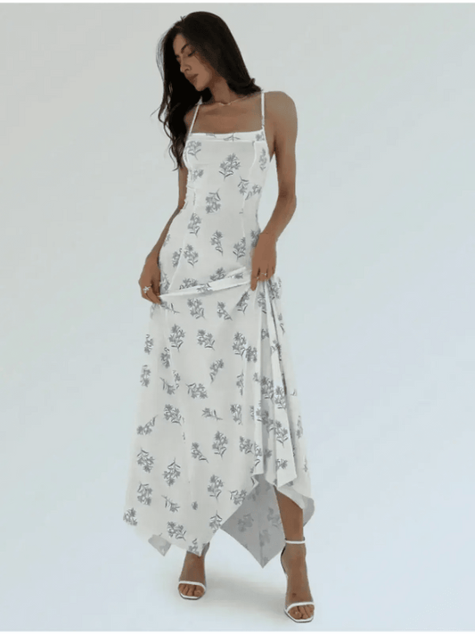 Model showcasing the Maxi Dress Bluebelle with a floral print and handkerchief hem, perfect for summer occasions.