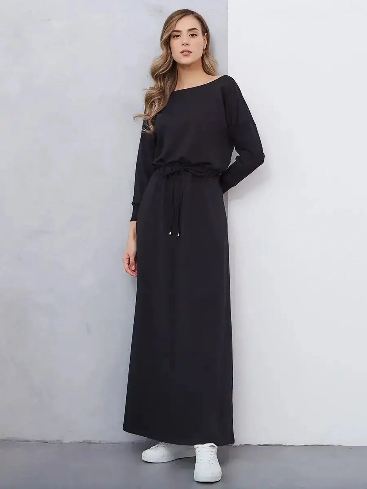 Sleek black maxi dress with cinched waist and relaxed fit, perfect for casual or formal occasions.