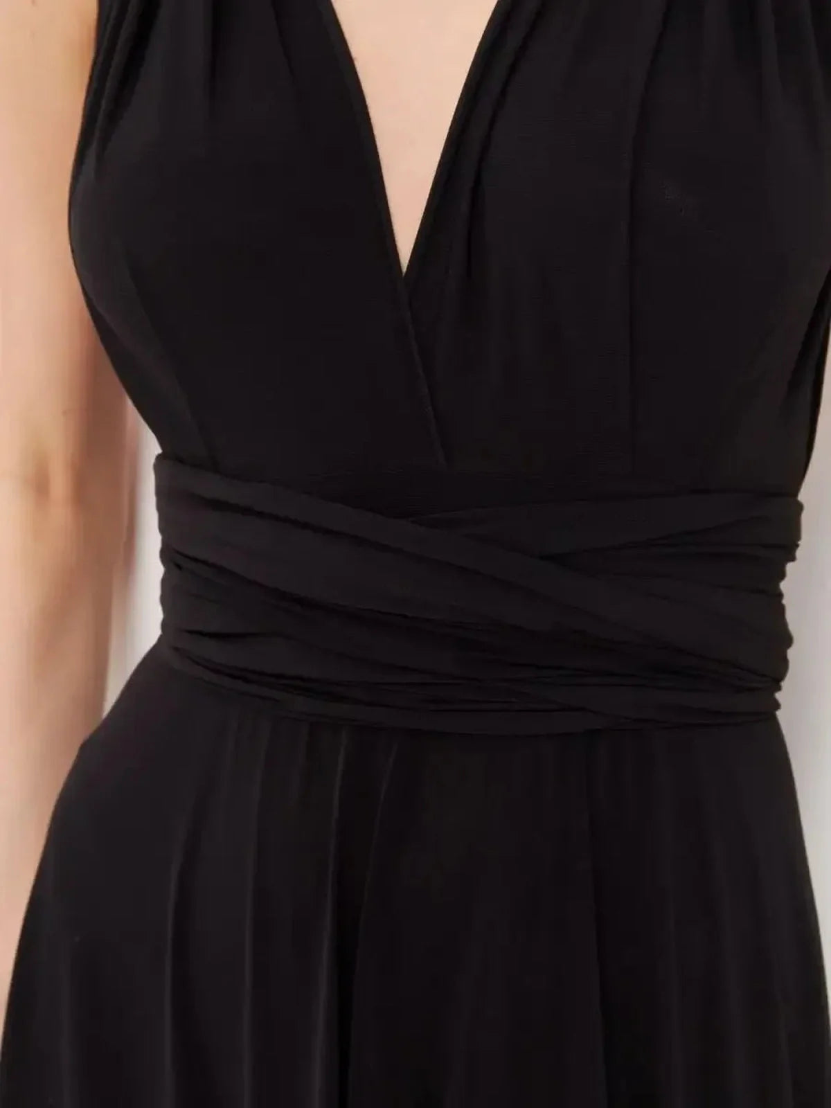Close-up of the elegant V-neckline and draped waistband of the Maxi Dress Eclipse Drape in black.