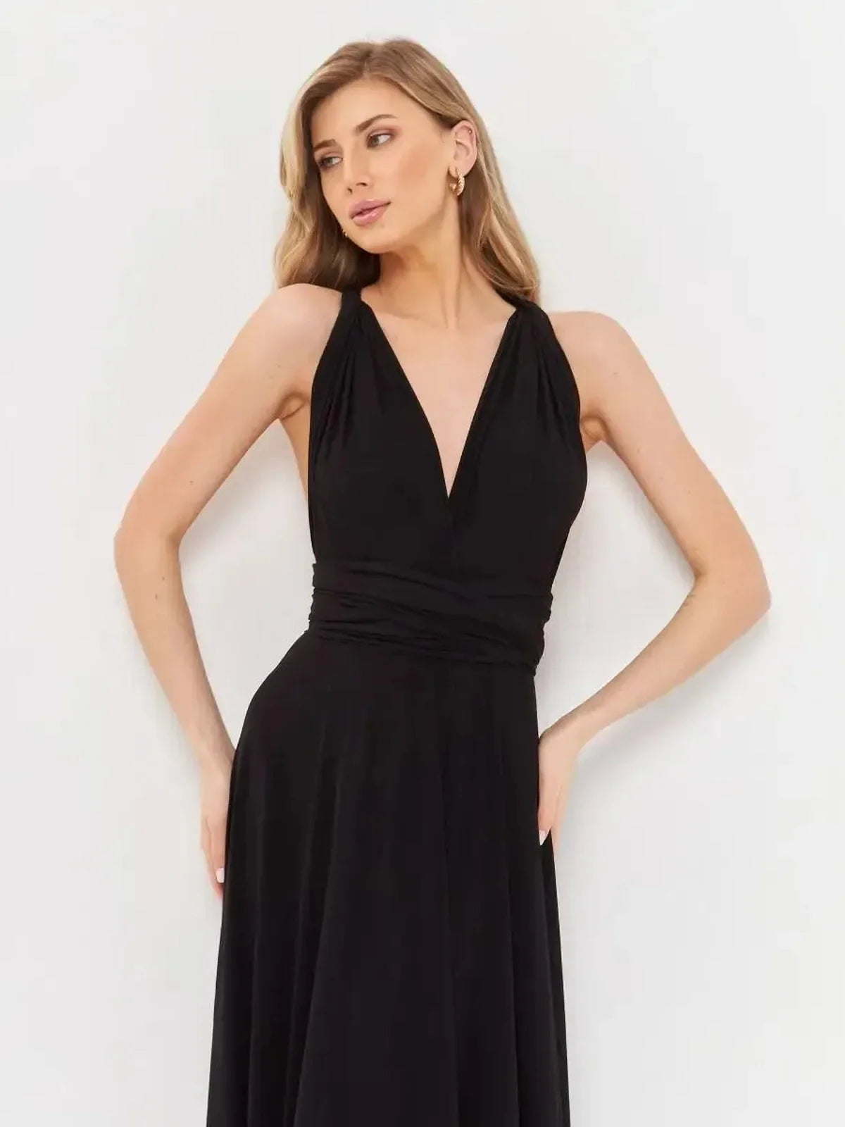 Elegant V-neck convertible black maxi dress with draped silhouette, showcasing a model in profile.