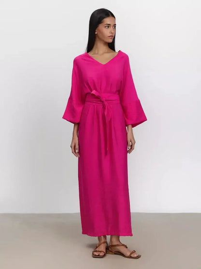 Model wearing a vibrant fuchsia maxi dress with kimono sleeves and a removable belt for a relaxed fit.