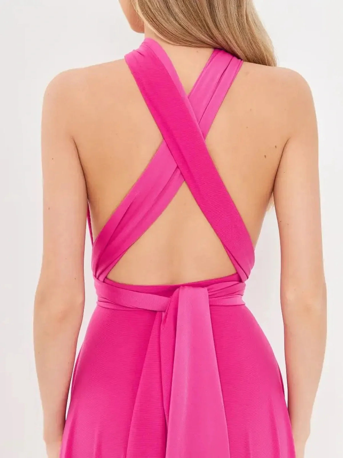 Back view of pink fuchsia maxi dress with crossed halter straps and adjustable wrap tie, showcasing its elegant design.