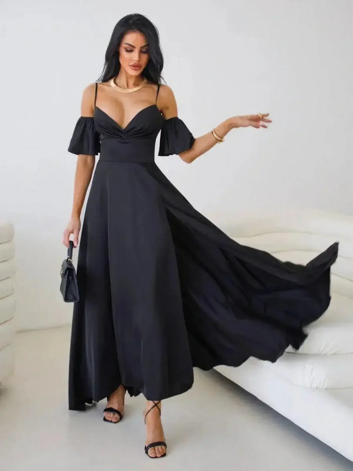 Elegant black maxi dress with off-shoulder flutter sleeves and thigh-high slit, showcasing a sophisticated silhouette.