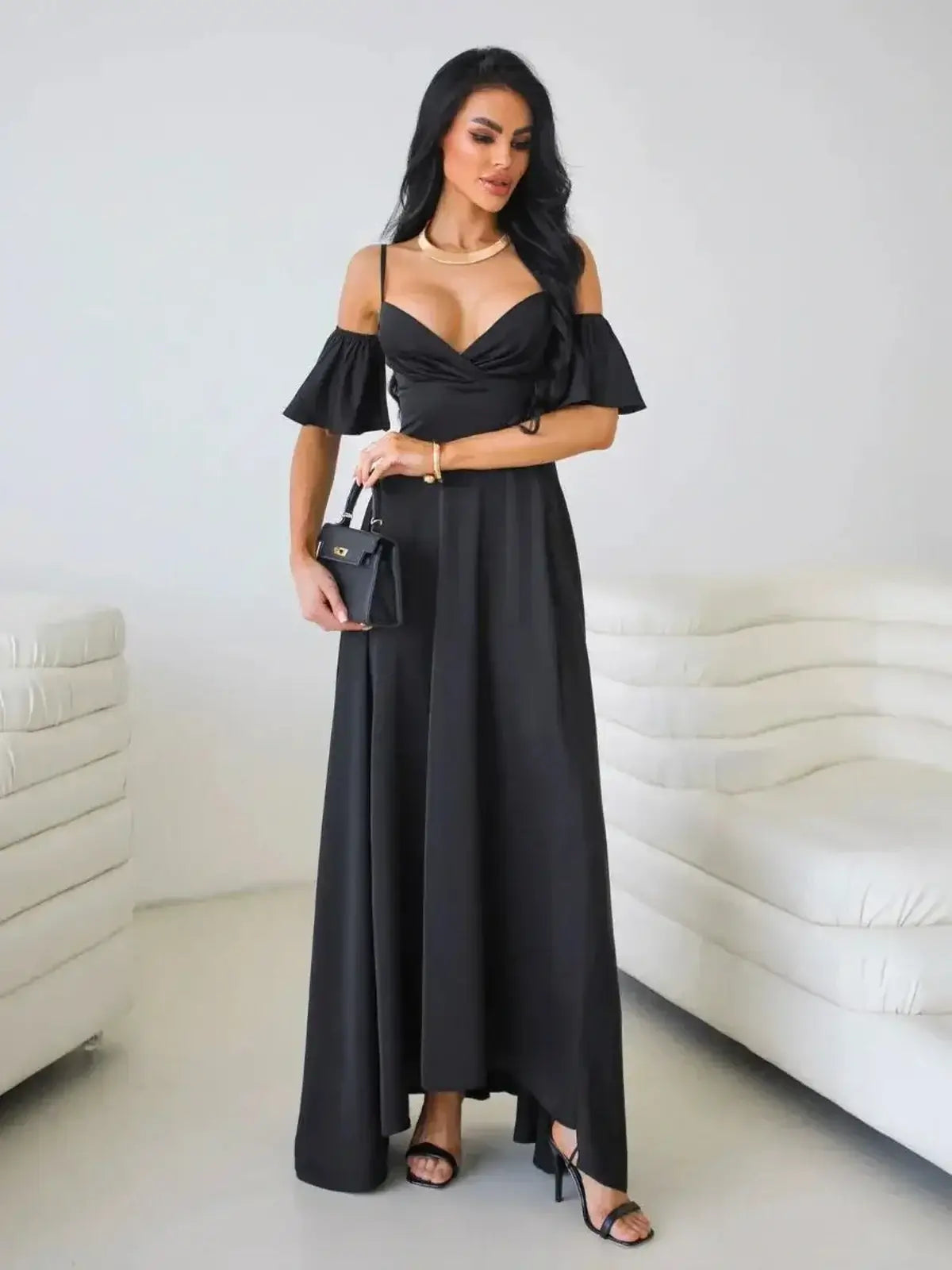 Elegant black maxi dress with off-shoulder flutter sleeves and thigh-high slit, showcasing a modern silhouette.