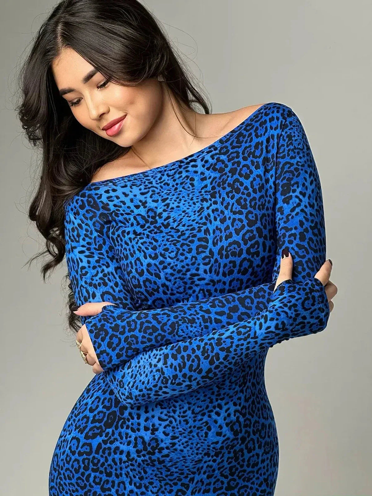 Model in a sleek blue leopard print maxi dress showcasing a long sleeve silhouette, ideal for modern events.