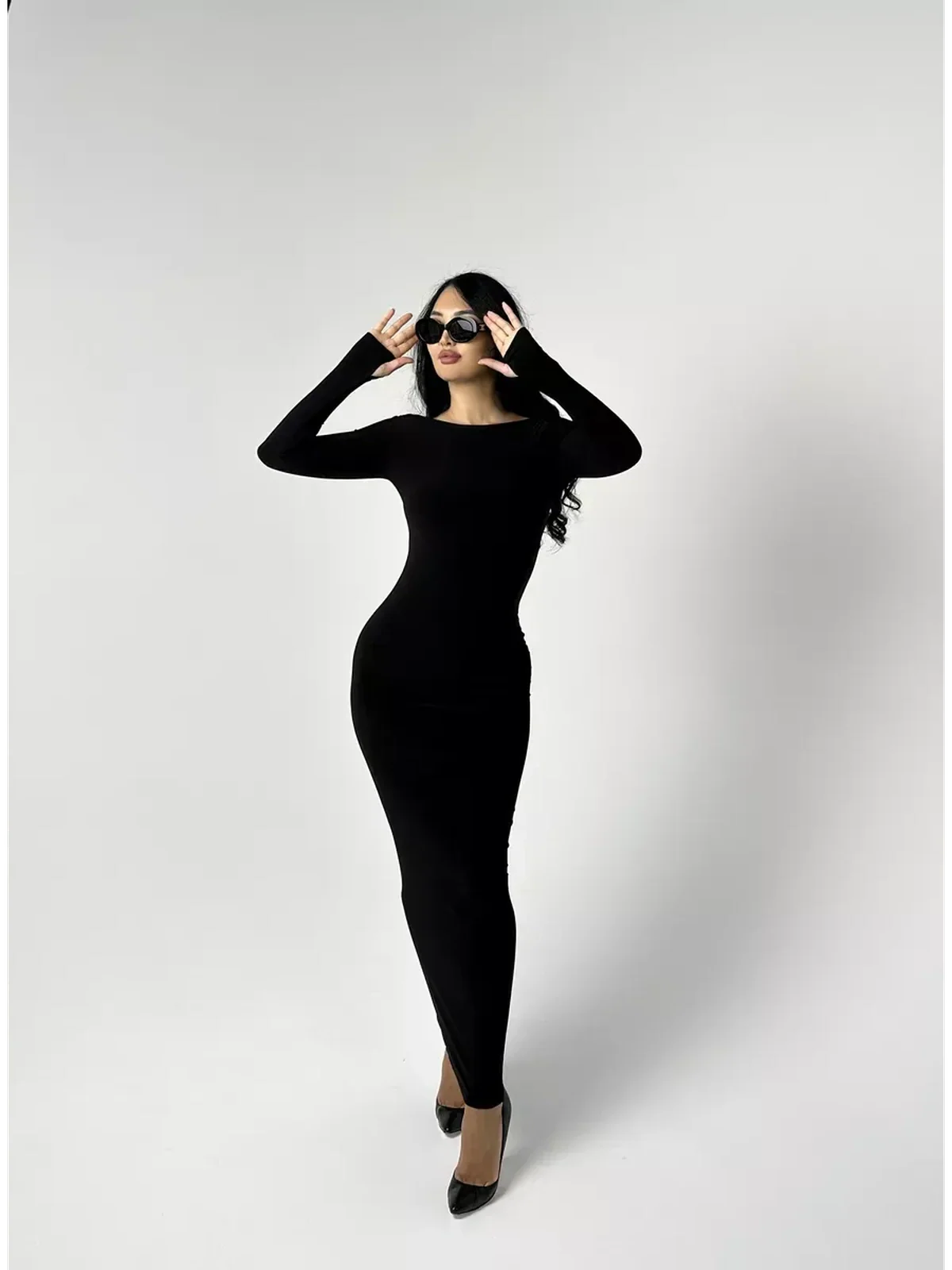Model wearing the elegant Maxi Dress Noir Allure, showcasing its black long sleeve bodycon silhouette.