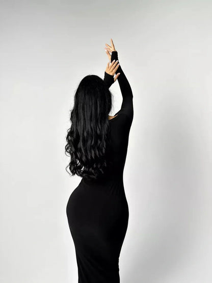 Elegant woman in a black long sleeve bodycon maxi dress showcasing a sleek silhouette and modern style.