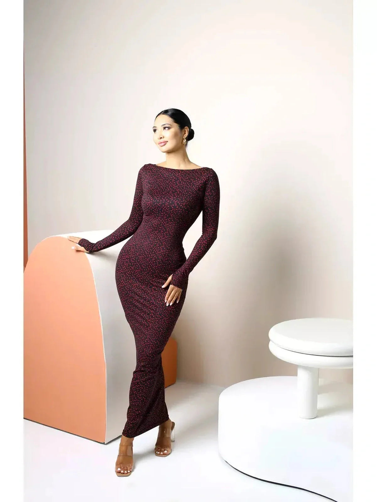 Elegant woman in a long sleeve black bodycon maxi dress with heart print, showcasing sophistication and style.