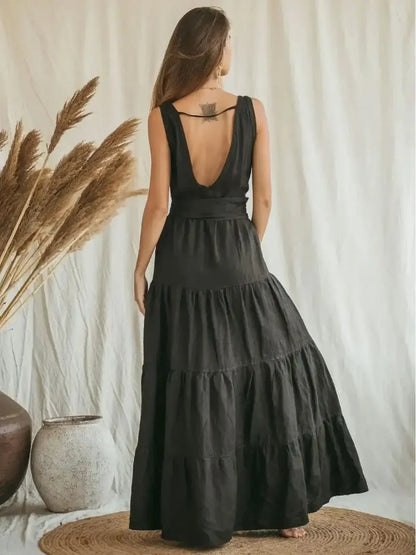 Back view of the Maxi Dress Noire Essence, featuring a deep V-neck and flowing tiered skirt in breathable linen.