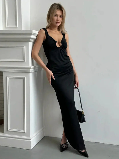 Model wearing the Maxi Dress Obsidian Charm with a plunging neckline and gold ring detail, showcasing a sultry silhouette.