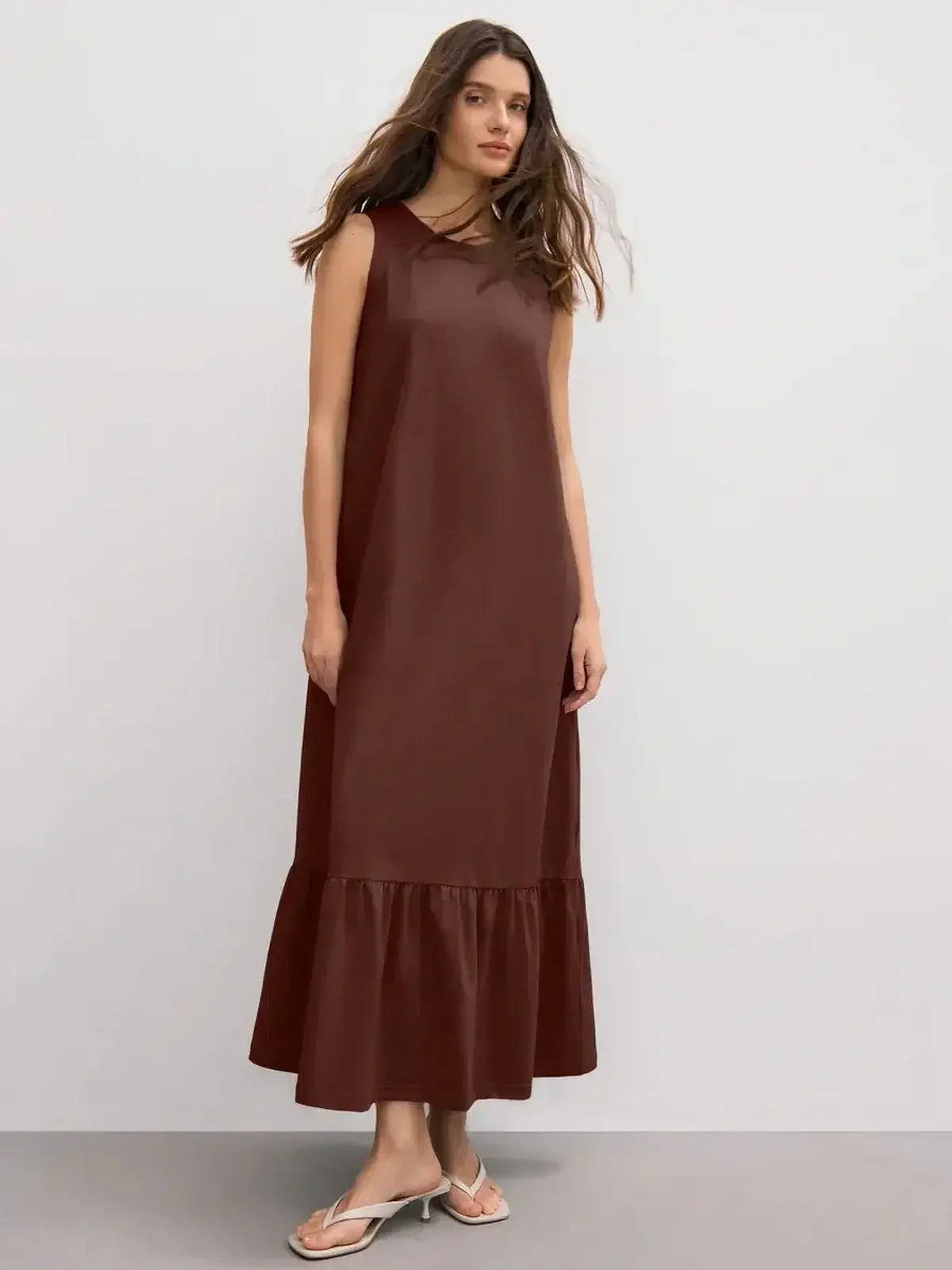 Sleeveless chocolate maxi dress with ruffle hem, perfect for elevated casual looks and comfortable movement.