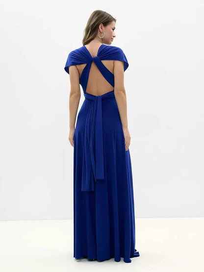 Back view of a woman in a vibrant blue Maxi Dress Sapphire Twist, showcasing an intricate twisted open back design.