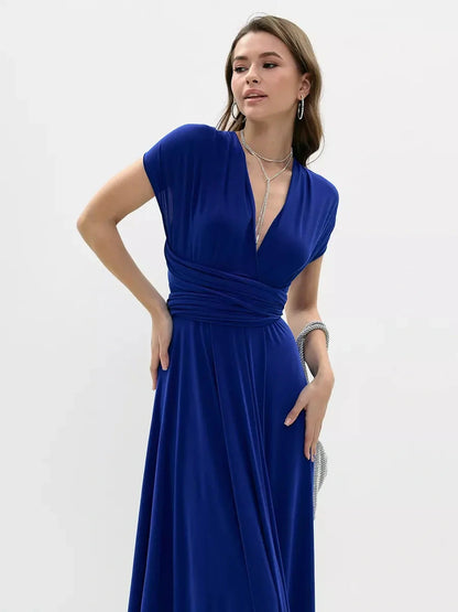 Model wearing a vibrant blue maxi dress with a twist design, showcasing elegance and style.