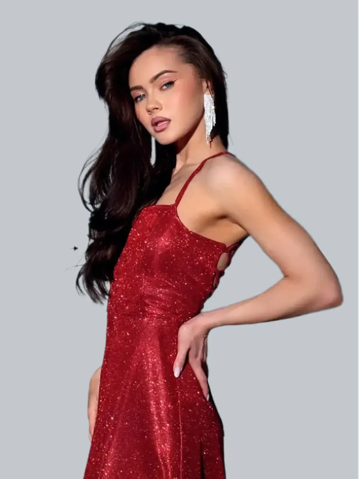 Model in a red shimmer maxi dress with a strappy open back, showcasing an elegant silhouette and sparkling fabric.