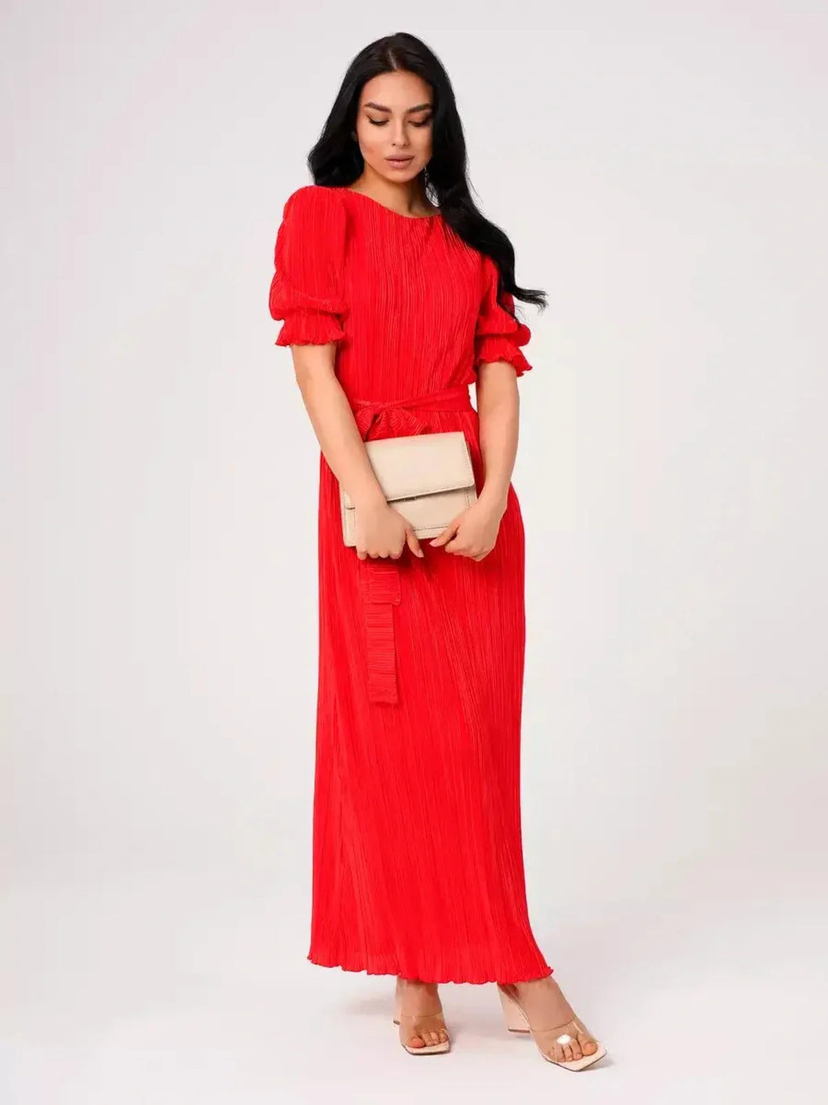 Red Maxi Dress Solaria with pleats and puff sleeves, styled with a clutch for elegant summer events.