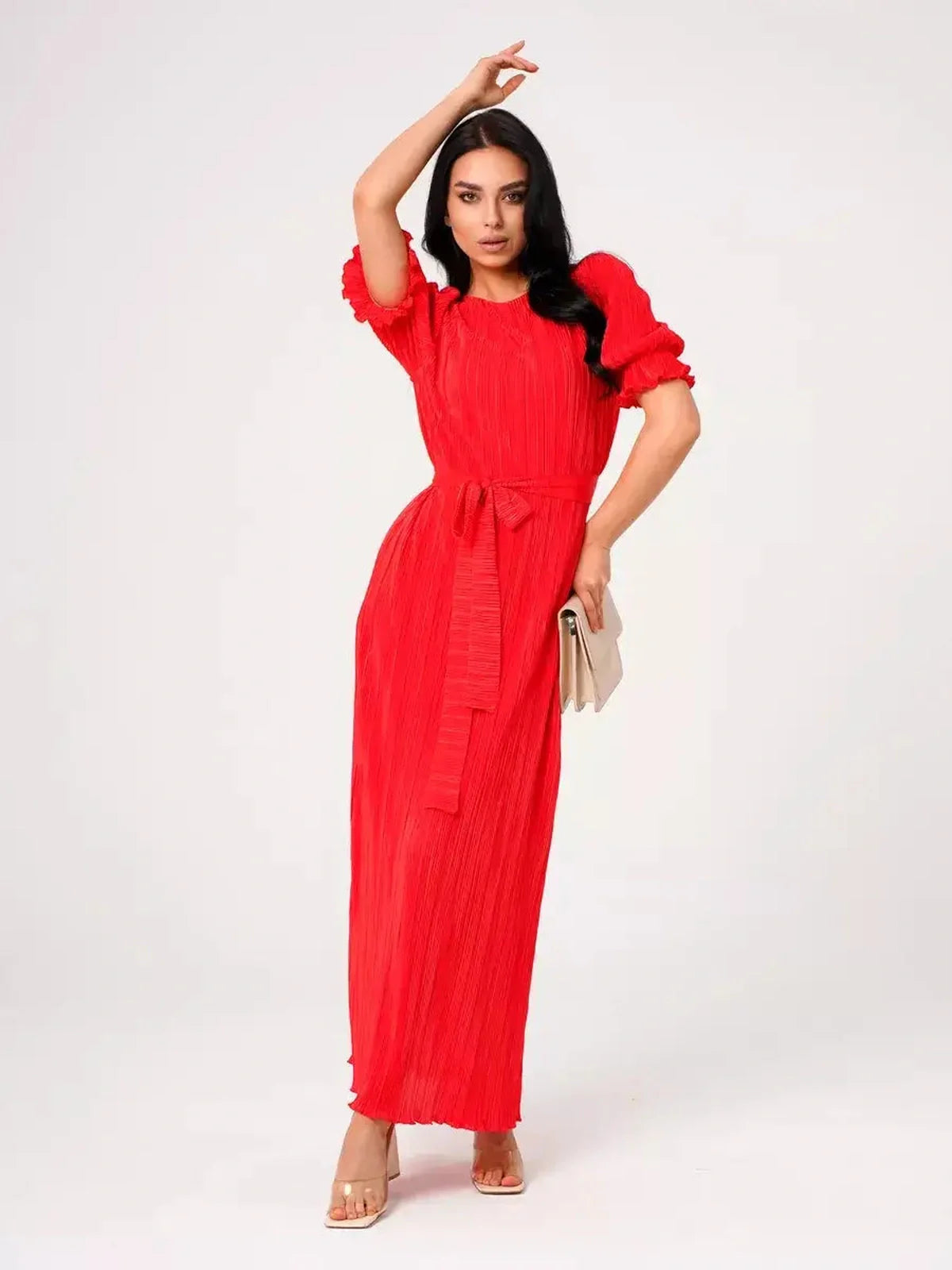 Stylish woman in a red pleated maxi dress with puff sleeves and a belted waist, perfect for summer events.
