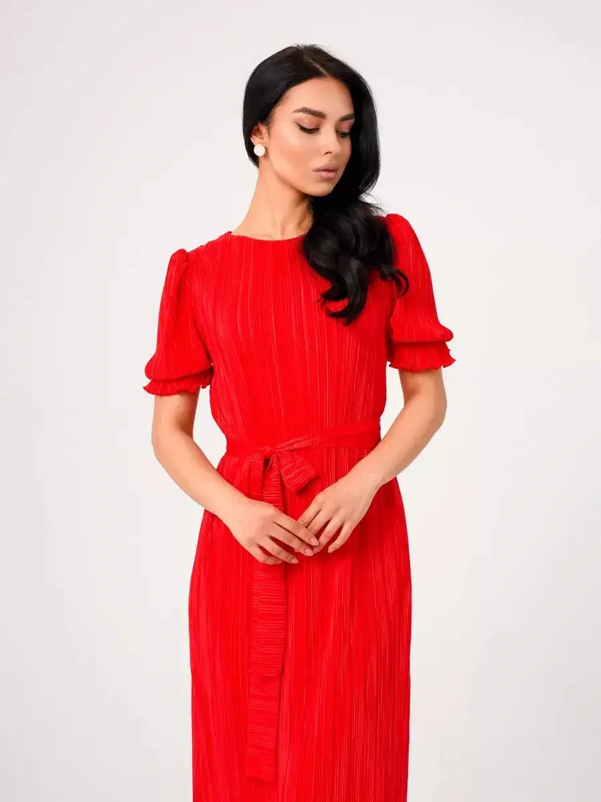 Model wearing a vibrant red Maxi Dress Solaria with pleats and a belted waist, perfect for summer events.