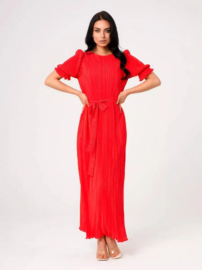 Model wearing the vibrant red Maxi Dress Solaria featuring pleated design and a belted waist.