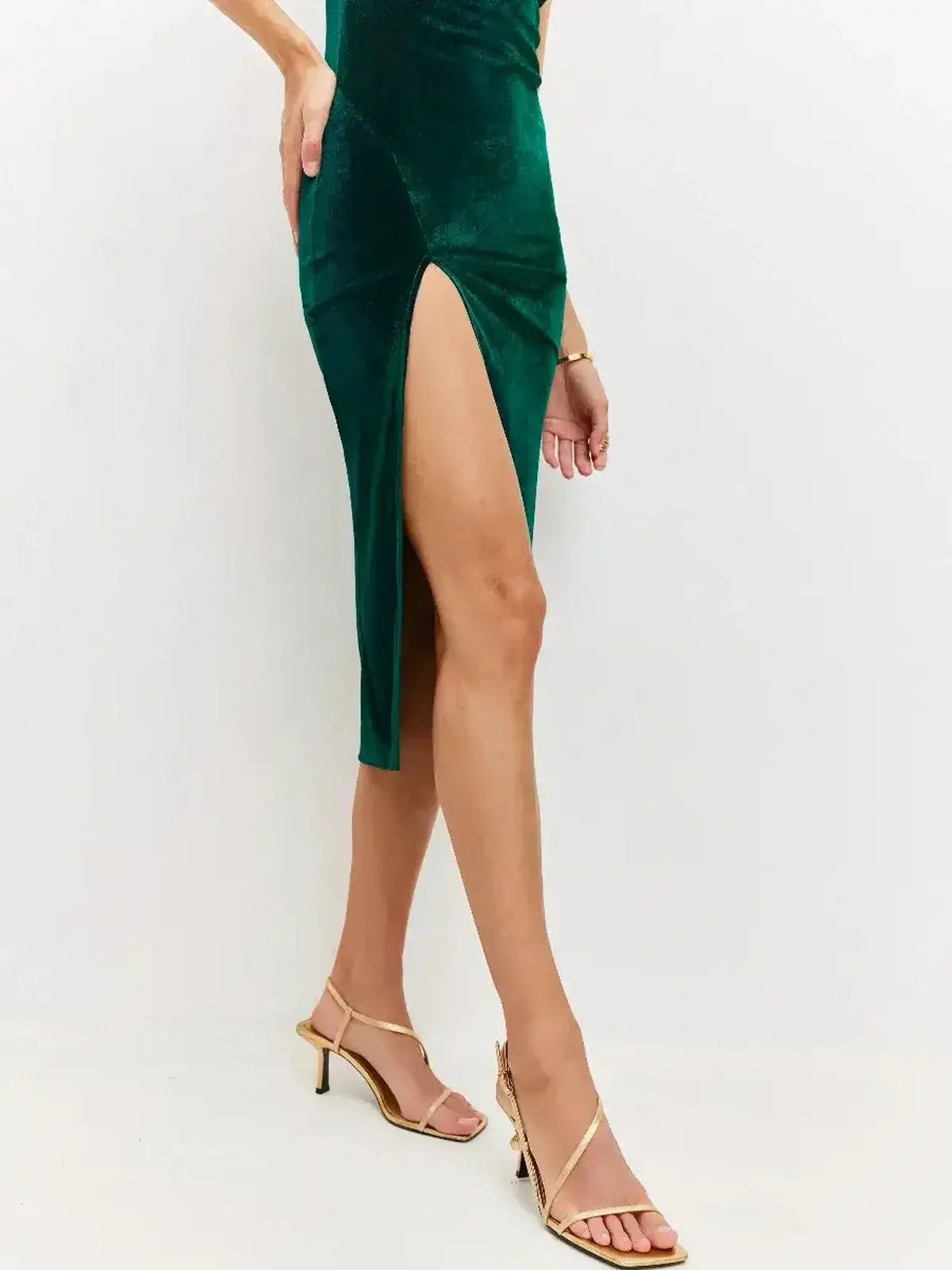 Model showcasing the Midi Dress Emerald Dusk by Lauven featuring a deep slit and plush velvet texture.