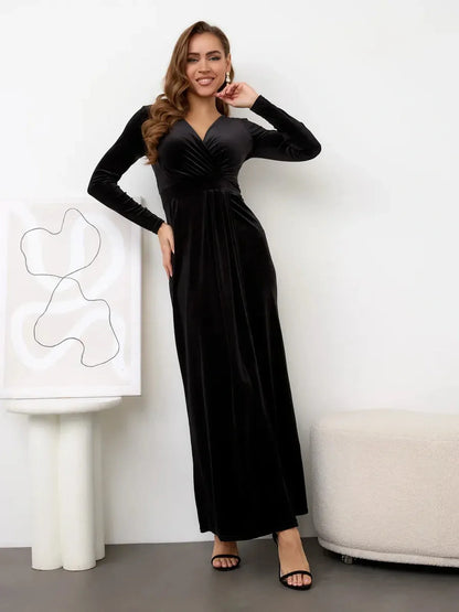 Model wearing the Midnight Allure Maxi Dress in black velvet, featuring a thigh-high slit and V-neckline.