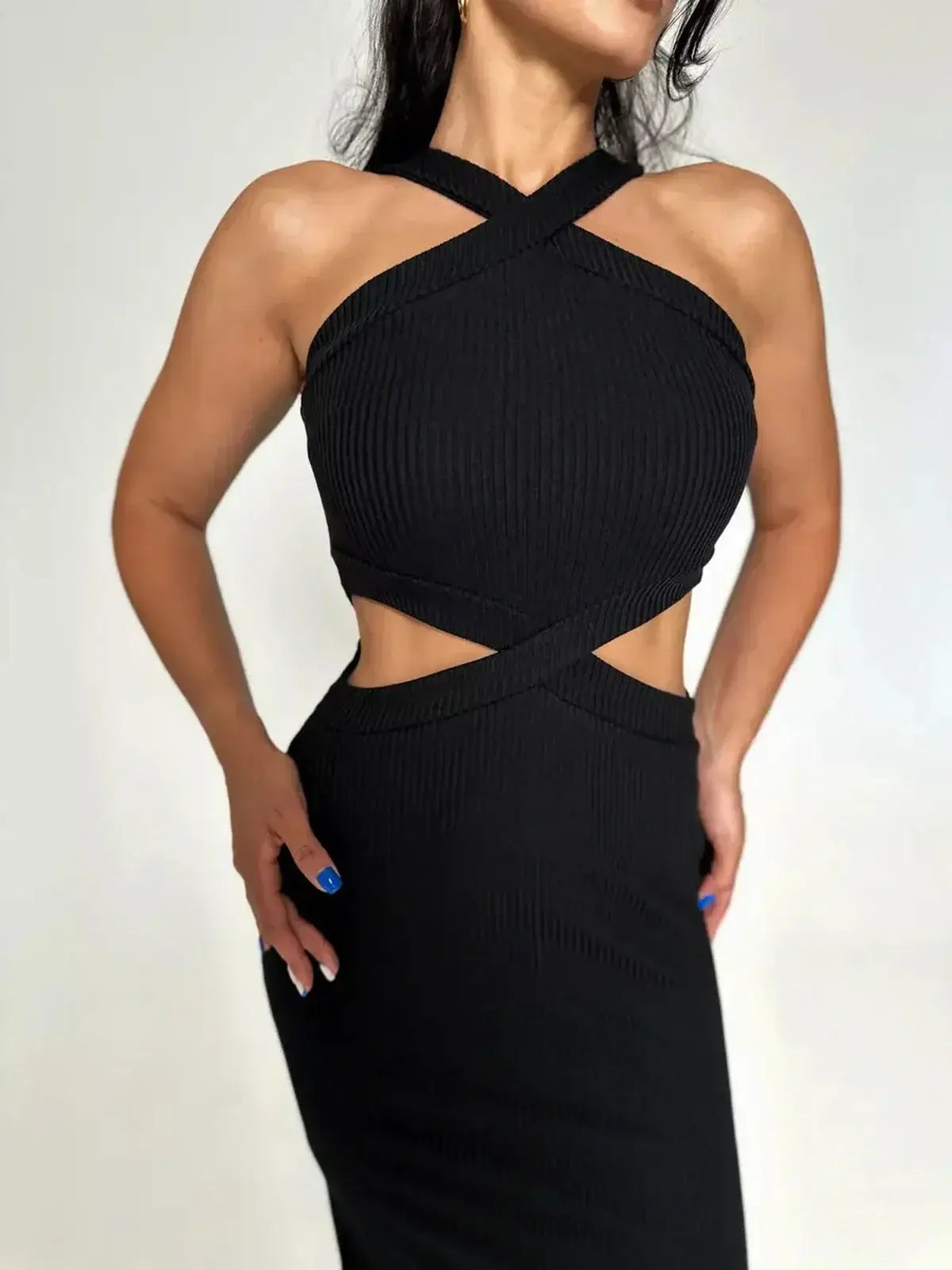 Model showcasing the Midnight Allure Midi Dress with a cross-strap neckline and cutout waist in elegant black ribbed fabric.