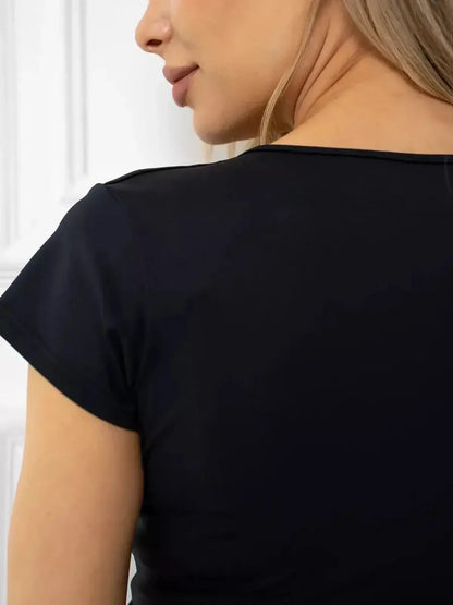 Close-up of the back of a sleek black mini dress with short sleeves, showcasing its breathable fabric.