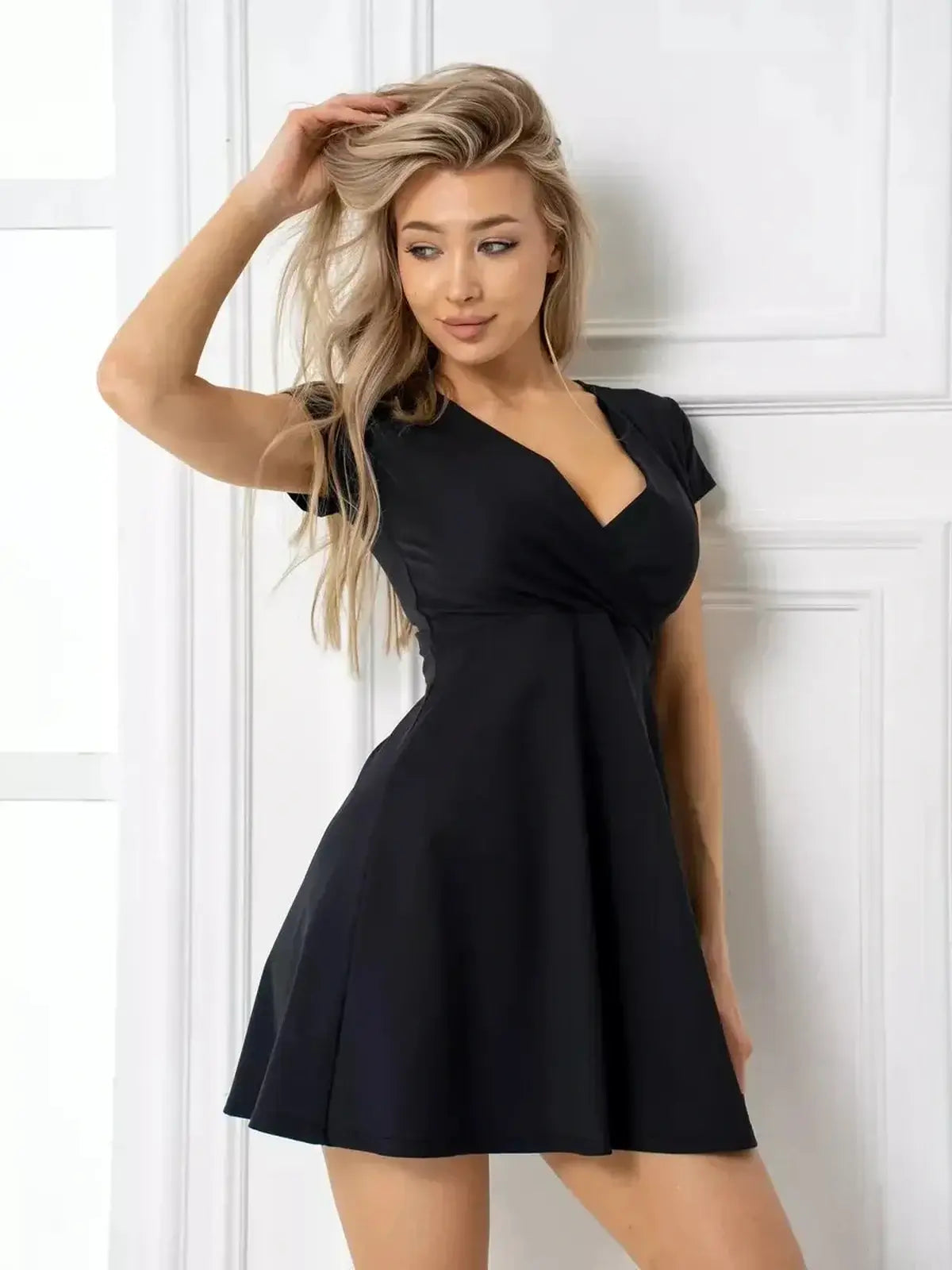 Black mini dress with a deep V-neckline and A-line skirt, perfect for summer and wedding guest occasions.