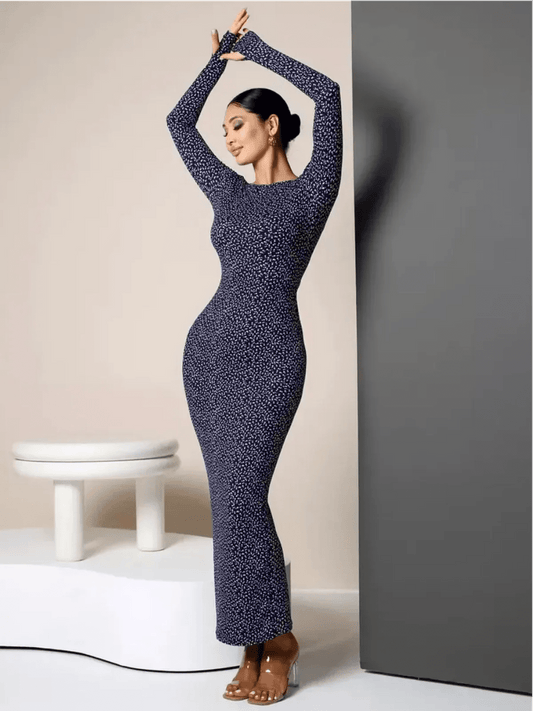 Model in Midnight Curve Maxi Dress showcases sculpted fit and elegance, featuring dark navy color and thumbhole sleeves.
