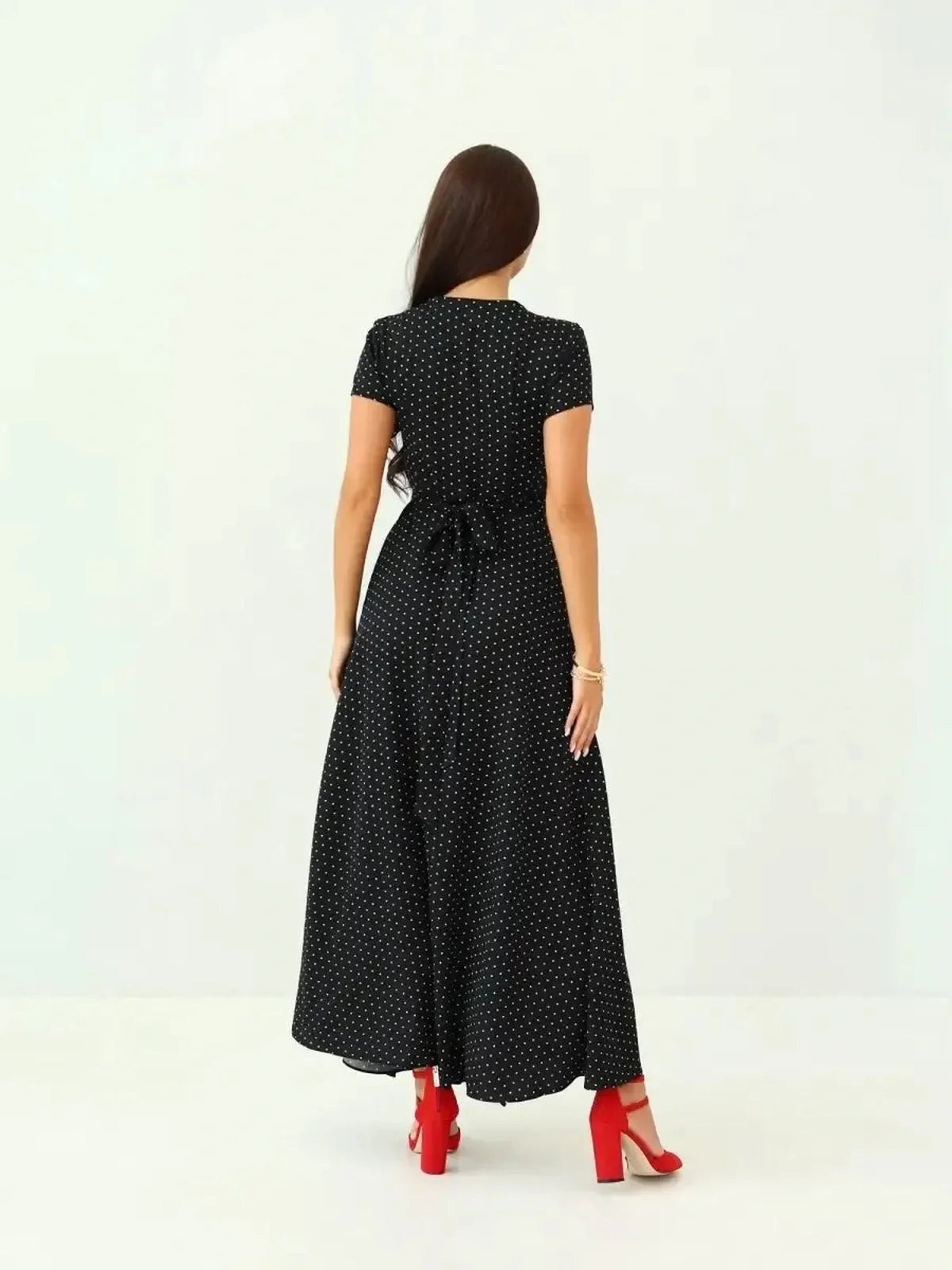 Back view of Midnight Dots Maxi Dress showcasing wrap silhouette and airy short sleeves, paired with red heels.