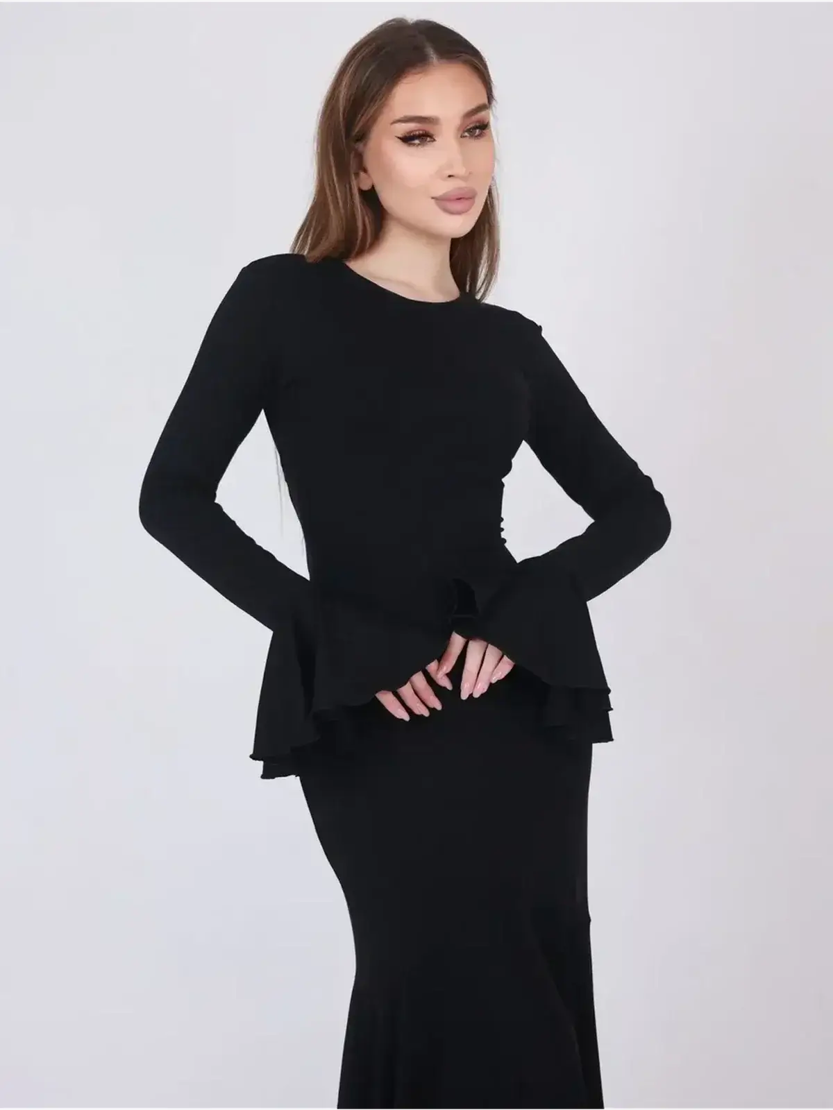 Mirage Maxi Dress featuring a sleek black design with flared cuffs and a flattering fishtail hem for elegant evening wear.