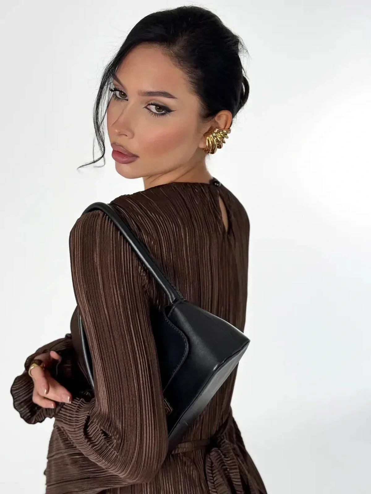 Model showcasing the Mocha Drape Maxi Dress with pleated details and a stylish black handbag.
