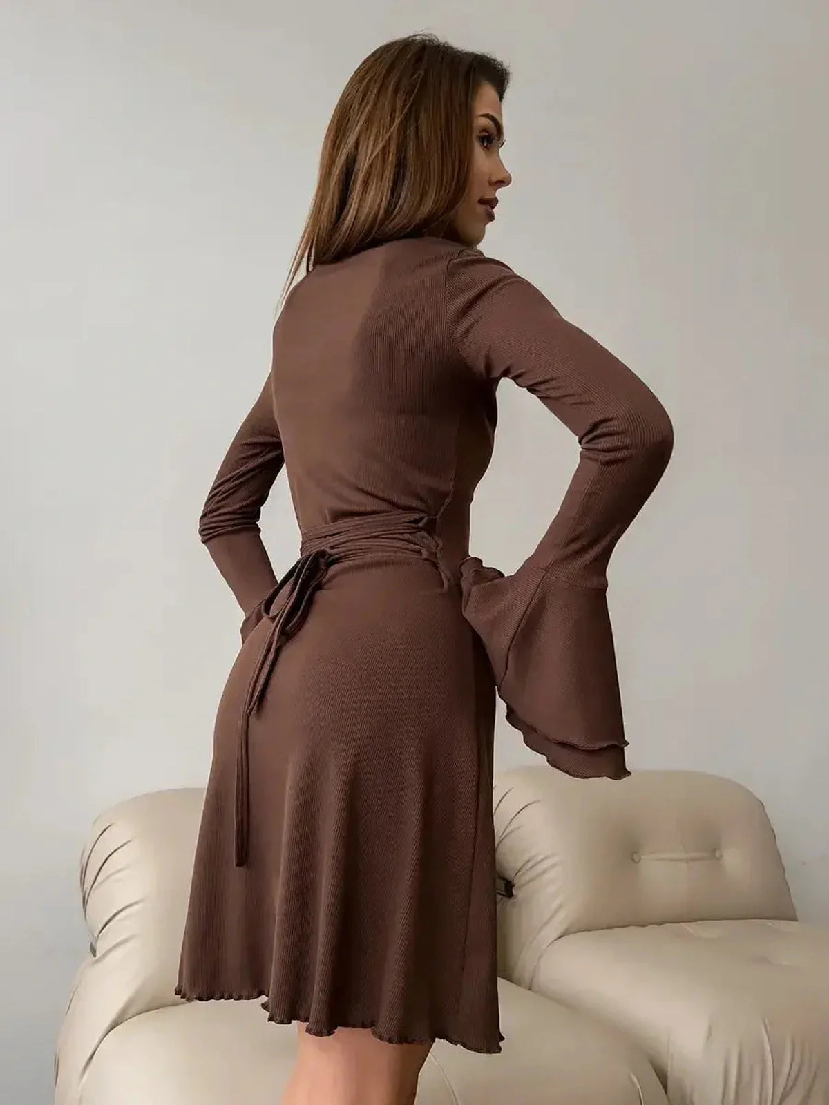 Women in a Mocha Flare Mini long sleeve dress with flared bell sleeves, showcasing a stylish rear view.