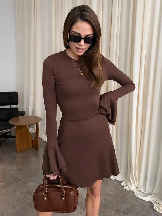 Chic Mocha Flare Mini dress with long sleeves and flared hem, styled with a brown handbag and sunglasses.