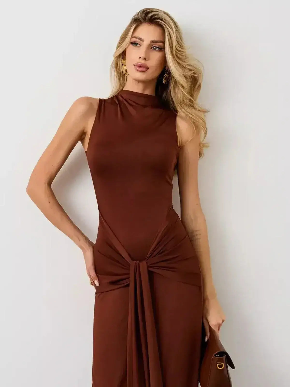 Elegant woman wearing the Mocha Muse Maxi Dress by Lauven, showcasing its sculptural fit and draped front knot.